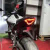Foco Integrado LED para Yamaha R3, R3A, MT-03, y MT-07 (2013 - 2017) 🔥 Este foco LED ahumado cuenta con 108 luces LED, incluyendo señales de dirección secuenciales, ofreciendo un diseño futurista y deportivo que complementa la estética de las motocicletas. El parpadeo secuencial mejora la visibilidad y asegura mayor atención comparado con las luces tradicionales. Características: Material: 108 perlas SMD de alto brillo, carcasa de plástico ABS de alta resistencia. Fuente de luz: LED. Voltaje de entrada: 12V. Carcasa: Color negro. Lentes: Ahumadas. Impermeabilidad: IPX5. Este foco LED es altamente eficiente, resistente a bajas temperaturas, con bajo consumo de energía, ofreciendo durabilidad y ahorro energético superior. Ideal para mejorar la visibilidad y la apariencia de tu motocicleta. Compatible con: Yamaha R3, R3A, MT-03, MT-07 (2013 - 2017). Conexiones: Negro: Polo negativo. Rojo: Luces de conducción. Verde: Luz de freno (intermitente continuo). Azul: Señal de giro izquierda. Azul: Señal de giro derecha.