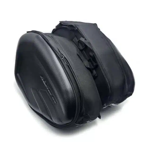 ALFORJAS LATERALES SEMIRRÍGIDAS TAICHI TIPO CARBÓN Las alforjas laterales TAICHI son la solución ideal para transportar tus pertenencias sin sacrificar estilo ni comodidad. Con diseño semirrígido tipo carbono, ofrecen un equilibrio perfecto entre estructura firme y flexibilidad, adaptándose tanto a viajes largos como al uso diario. Características: • Estructura semirrígida con acabado tipo carbono • Capacidad de 18 a 29 litros por alforja gracias a su sistema expandible • Medidas: 45 cm de largo x 30 cm de alto x 18 cm de ancho (expandible a 28 cm) • Amplio espacio para herramientas, documentos o casco • Cierres de alta calidad para mayor seguridad • Incluyen múltiples correas ajustables para una instalación firme y adaptable • Color disponible: negro • Funda impermeable incluida para proteger contra la lluvia y la suciedad Estas alforjas combinan funcionalidad y diseño, ideales para quienes buscan practicidad y estilo en cada ruta.