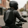 MOCHILA AERODINÁMICA TIPO CAPARAZÓN Diseñada especialmente para motociclistas, esta mochila tipo caparazón combina aerodinámica, capacidad y protección. Su estructura rígida y diseño compacto la convierten en la compañera ideal para quienes necesitan transportar objetos de forma segura y sin comprometer el rendimiento sobre la moto. Características: • Caparazón semi rígido con funda impermeable incluida • Capacidad aproximada de 25 litros • Diseño aerodinámico que reduce la resistencia al viento • Compartimento interno acolchado para notebook • Cierre expansible: añade hasta 12 cm de capacidad extra • Broches en pecho y cintura para mayor estabilidad • Tela transpirable para mejor ventilación • Medidas: 51 cm largo x 35,5 cm ancho x 14 cm alto Con esta mochila llevas todo lo esencial con comodidad, seguridad y estilo, sin comprometer el rendimiento en tus rutas.